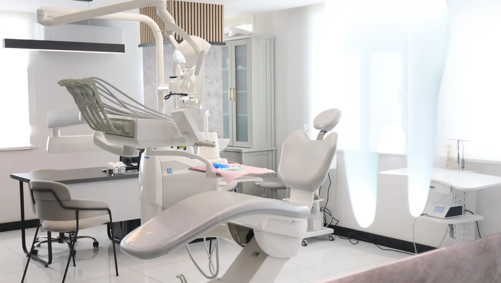 An empty dental treatment room with a dental chair and equipment.